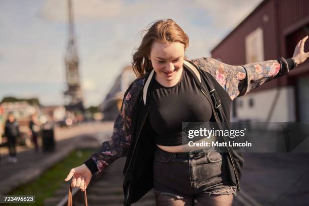 young woman balancing on train track, bristol, uk - bristol stock-fotos und bilder