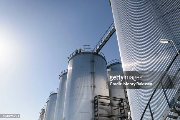 worker on top of storage tanks in oil blending factory - oil refinery stock pictures, royalty-free photos & images