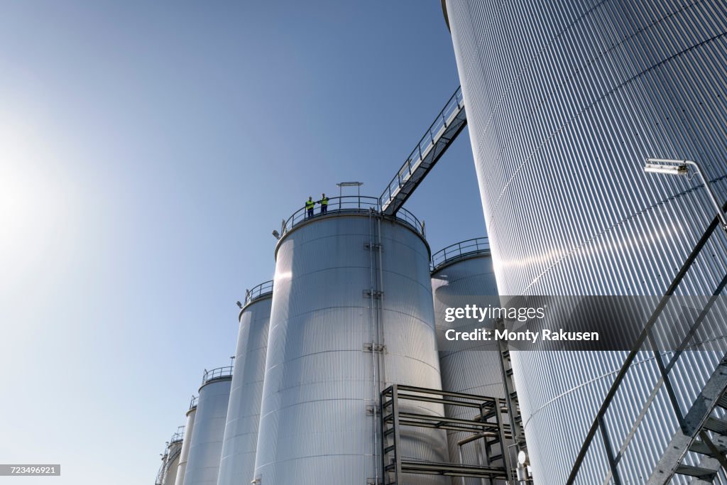 Worker on top of storage tanks in oil blending factory