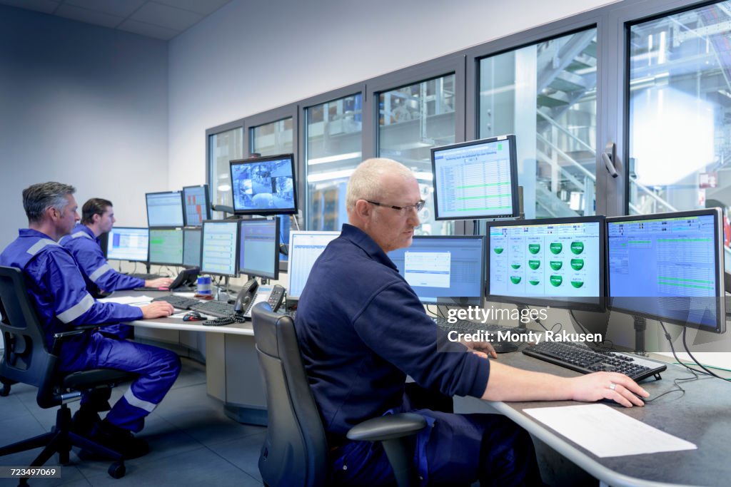 Workers in process control room in oil blending factory