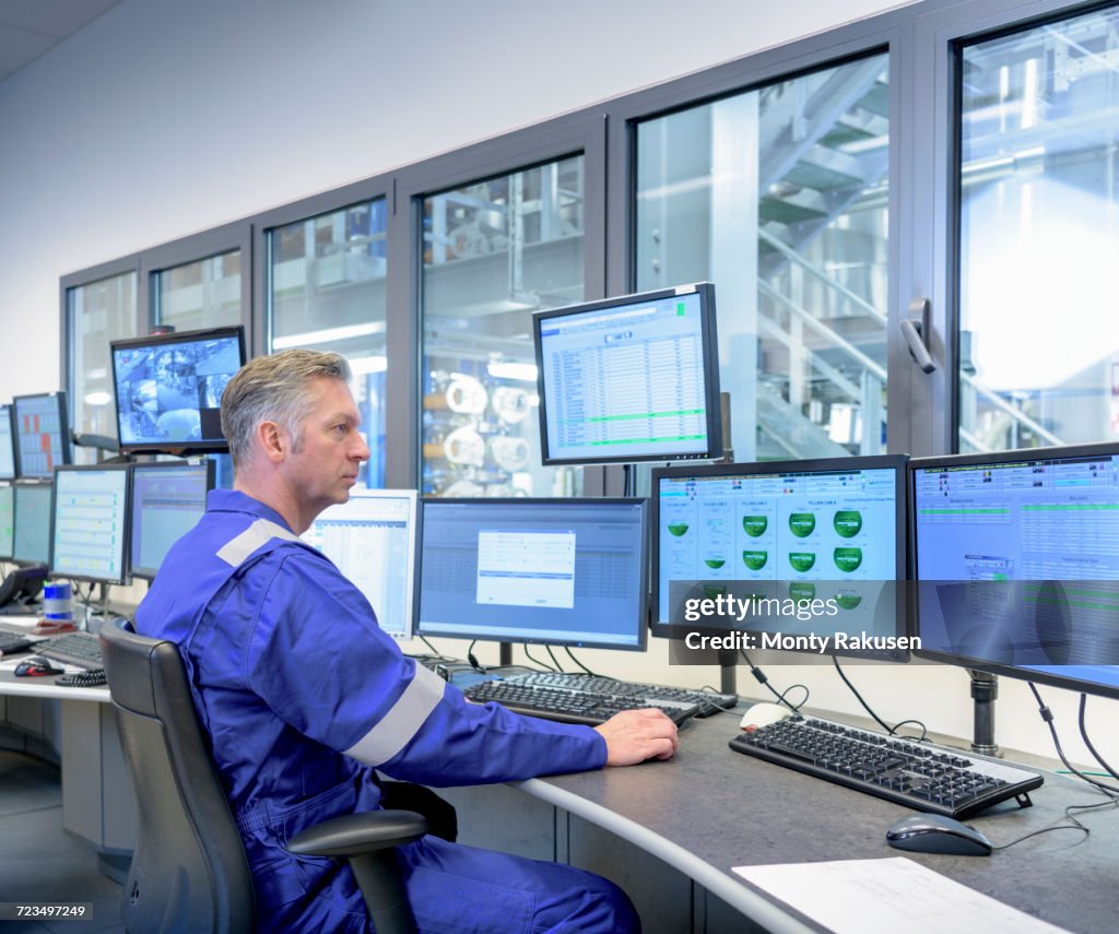 Workers in process control room in oil blending factory