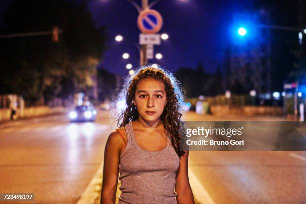 portrait of teenage girl in the middle of the road looking at camera - the runaways photos et images de collection
