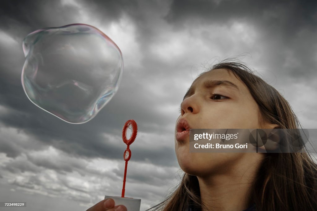 Girl blowing large soap bubble