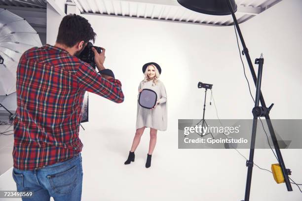 male photographer photographing female model on studio white background - male model casual imagens e fotografias de stock