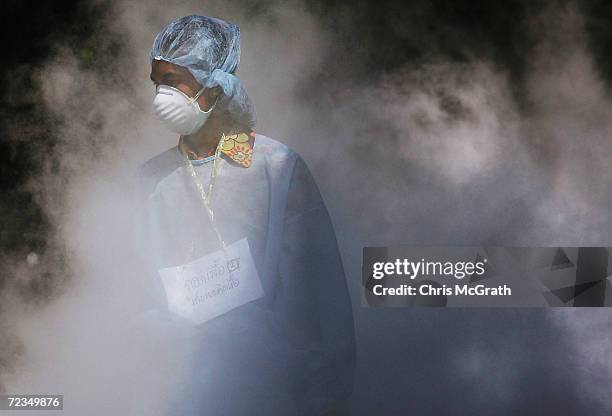 Medical worker walks through dry ice vapour at a makeshift morgue inside a Buddhist temple on January 2, 2005 in Takuapa, Thailand. The bloated and...