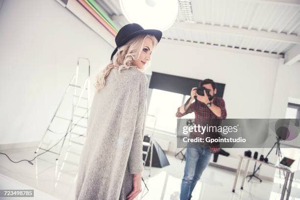 male photographer photographing female model on studio white background - fashion photographer stock pictures, royalty-free photos & images