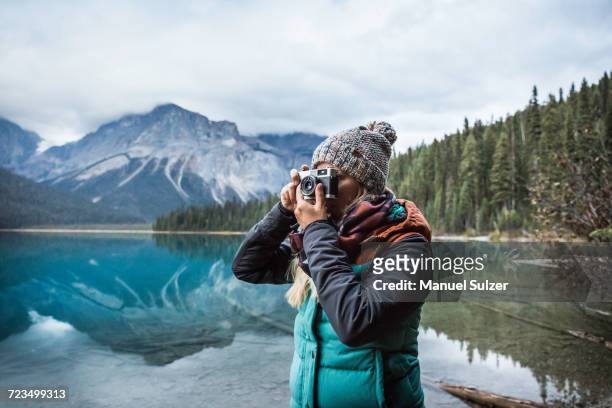 woman taking photograph of view, emerald lake, yoho national park, field, british columbia, canada - yoho national park photos et images de collection