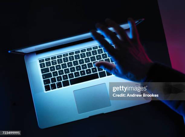 hacking, man opening laptop computer - threats stockfoto's en -beelden