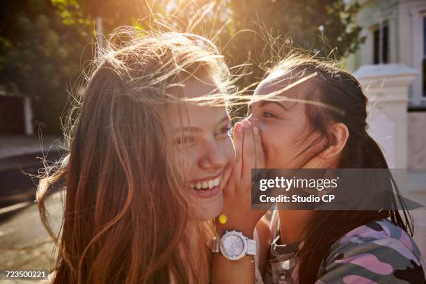 teenage girls having fun in residential street, cape town, south africa - whispering - fotografias e filmes do acervo