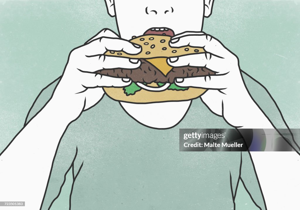 Close-up of man eating hamburger against colored background