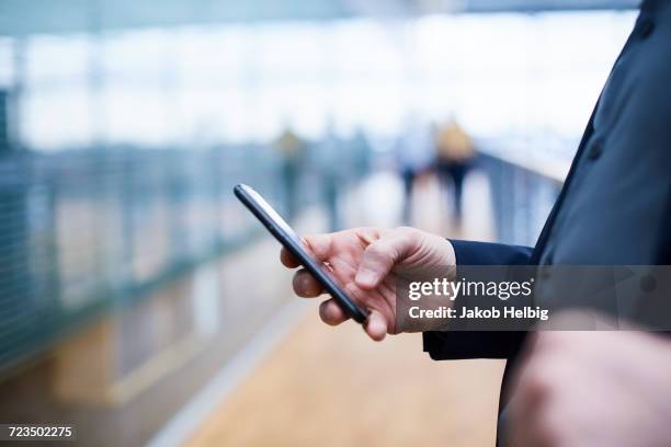 close up of businessman using smartphone on office balcony - suit hand stock-fotos und bilder