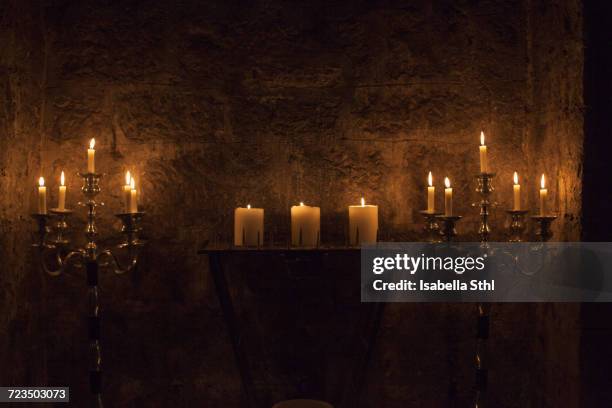 candles burning against stone wall - candlestick holder stock pictures, royalty-free photos & images