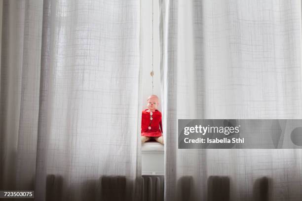 doll sitting on windowsill behind curtains - string stock pictures, royalty-free photos & images