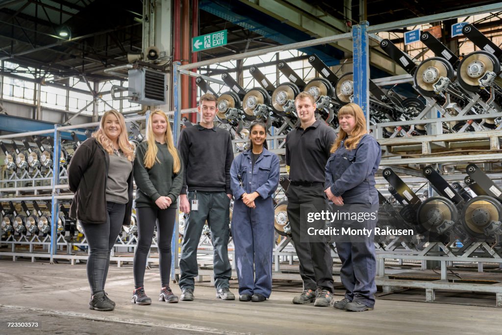 Group portrait of male and female apprentices in car factory