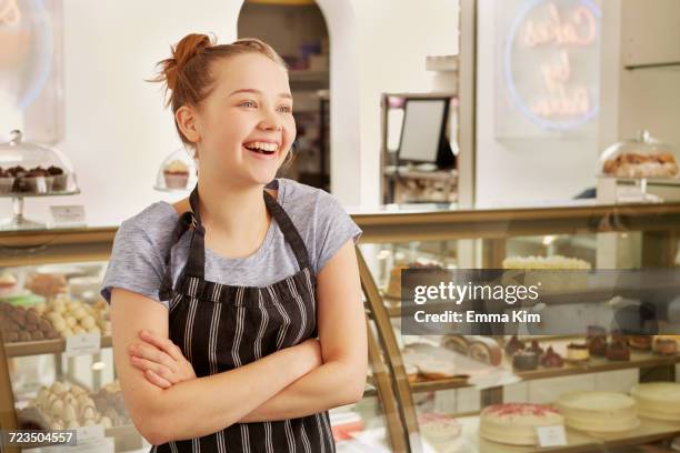 girl working in bakery looking away smiling - first job stock pictures, royalty-free photos & images