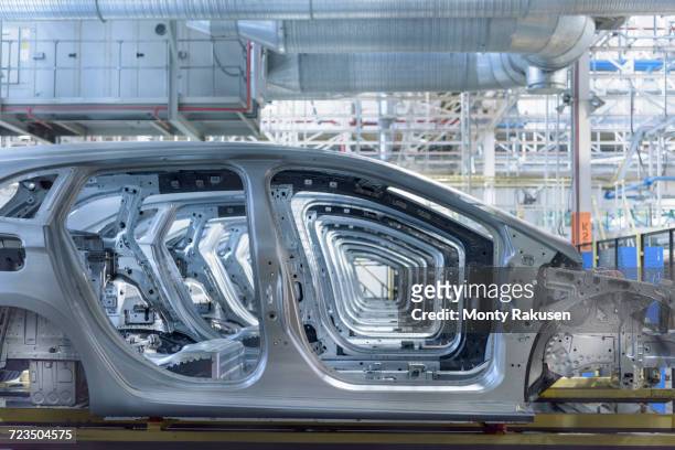view of cars on production line in factory - chassis stock-fotos und bilder