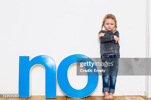 Young girl standing next to large three-dimensional letters, spelling the word NO Young girl standing next to large three-dimensional letters, spelling the word NO