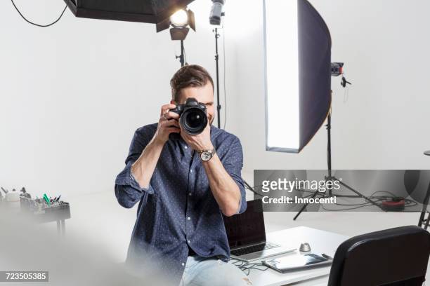 male photographer testing focus on digital slr in photography studio - sesion fotografica fotografías e imágenes de stock