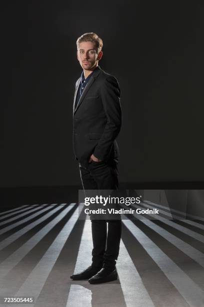 portrait of businessman wearing formals standing against black background - man in formals stockfoto's en -beelden