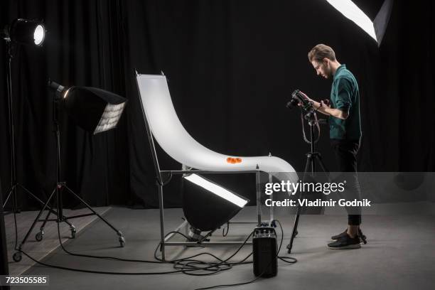 side view of confident photographer photographing food at studio - fotografie benodigdheden stockfoto's en -beelden