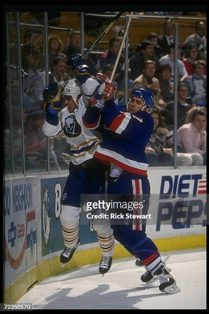 Defenseman Scott Lachance of the New York Islanders works against a Buffalo Sabres player during a game at Memorial Auditorium in Buffalo, New York.
