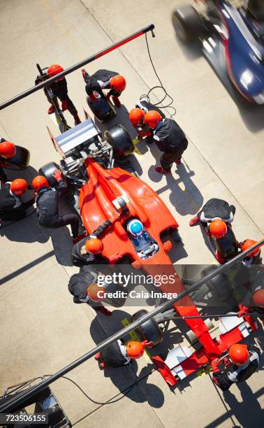 overhead pit crew working on open-wheel single-seater racing car race car in pit lane - pit stop top view stock pictures, royalty-free photos & images