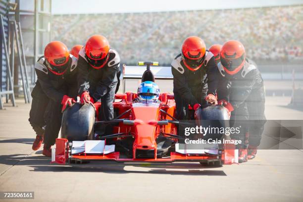 pit crew pushing open-wheel single-seater racing car race car out of pit lane - pitstop team stock pictures, royalty-free photos & images