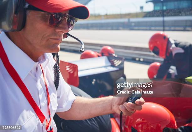 manager with stopwatch timing open-wheel single-seater racing car pit stop practice session - boxenstopp stock-fotos und bilder