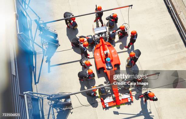 overhead pit crew replacing tires on open-wheel single-seater racing car race car in pit lane - pitstop team stock pictures, royalty-free photos & images