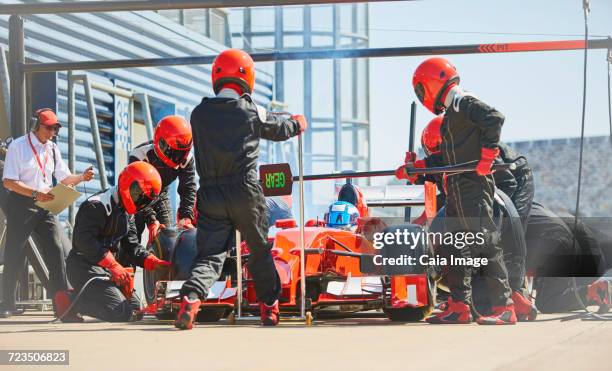 pit crew replacing tires on open-wheel single-seater racing car race car in pit lane - pit stop stock pictures, royalty-free photos & images