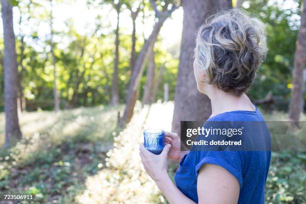 mature woman with drink looking out at rainforest, nosara, guanacaste province, costa rica - nosara costa rica stock pictures, royalty-free photos & images