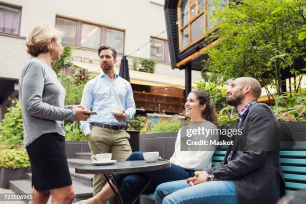 business people having coffee while discussing at office yard - garden office bildbanksfoton och bilder