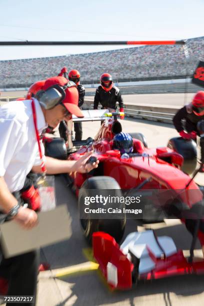 manager with stopwatch timing pit crew replacing tires on open-wheel single-seater racing car race car in practice session pit lane - qualifying race 28 stock pictures, royalty-free photos & images