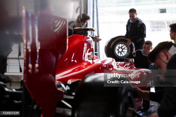 pit crew working on open-wheel single-seater racing car race car in repair garage - qualifying race 28 stock pictures, royalty-free photos & images