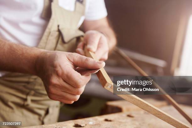 hands of male carpenter sanding frame at workbench - sandpapper bildbanksfoton och bilder