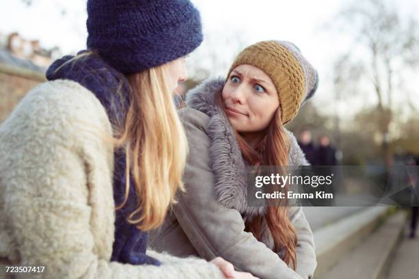 two female friends outdoors, sitting on steps, fooling around, pulling faces - shocked woman stock pictures, royalty-free photos & images