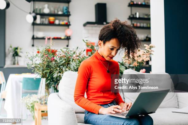 female florist using laptop at flower arranging workshop - reds training session stock pictures, royalty-free photos & images