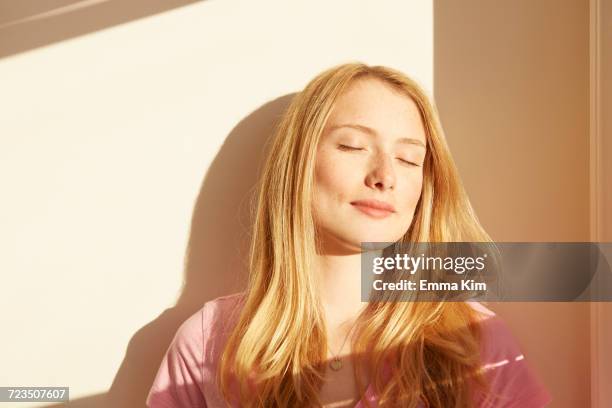 portrait of young woman, outdoors, in sunlight, eyes closed - vie londres soleil photos et images de collection