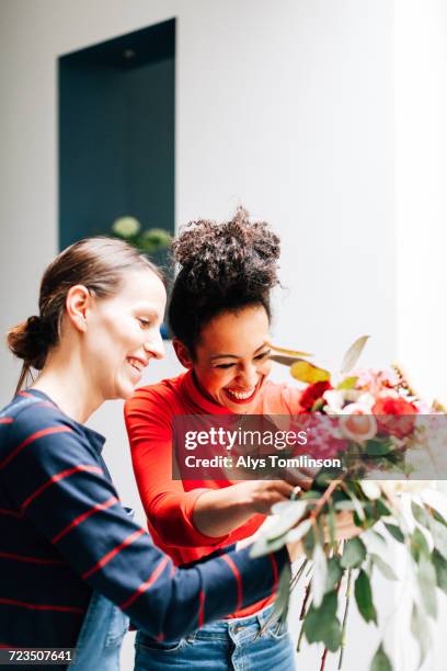 florist and student arranging bouquet at flower arranging workshop - arranging flowers stock pictures, royalty-free photos & images