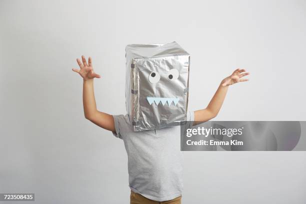 portrait of boy with silver box on head, funny face on box - monster bildbanksfoton och bilder