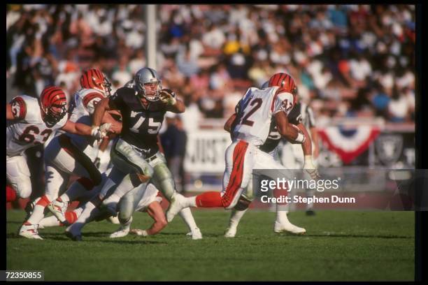 Defensive lineman Howie Long of the Los Angeles Raiders goes after Cincinnati Bengals running back Eric Ball during a playoff game at the Coliseum in...