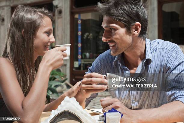 young couple sitting outside cafe, drinking coffee, turin, piedmont, italy - turin coffee stock pictures, royalty-free photos & images