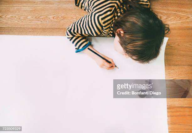 overhead view of boy drawing on large paper on floor - 9 hand drawn patterns stock pictures, royalty-free photos & images