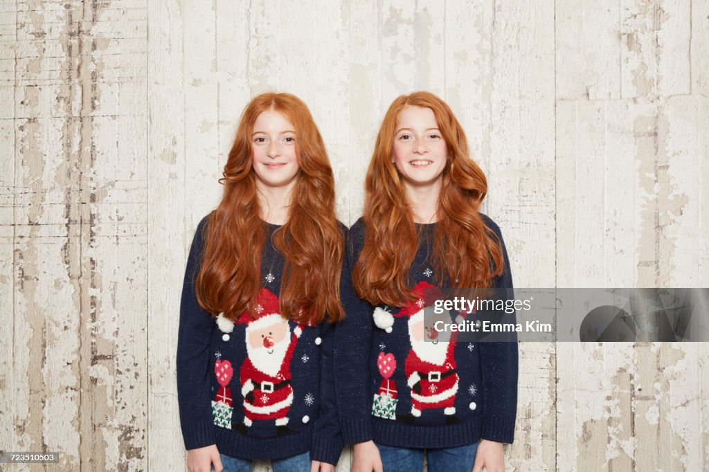 Portrait of twin sisters wearing Christmas jumpers