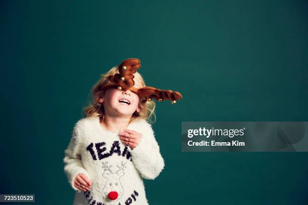 portrait of young girl wearing christmas and reindeer antlers - child christmas costume stock pictures, royalty-free photos & images