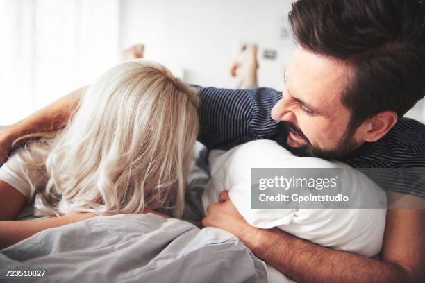 couple lying on bed, man tickling woman - tickling stock-fotos und bilder