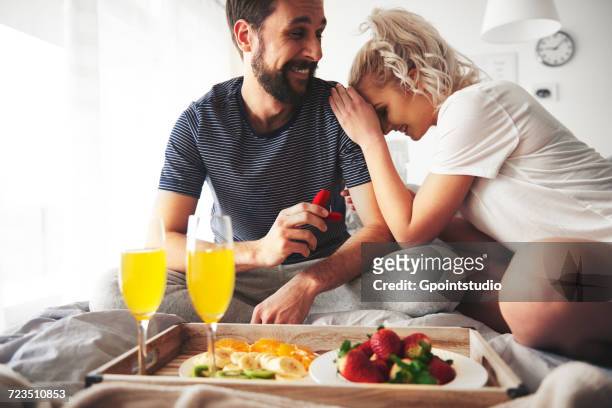 couple sitting on bed, man proposing, holding open ring box - man holding engagement ring - fotografias e filmes do acervo