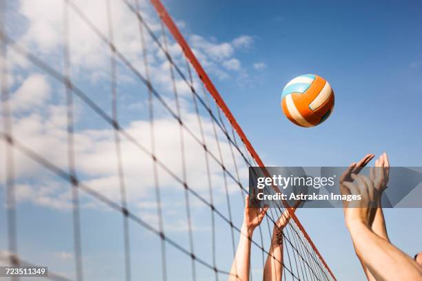 cropped image of people volleyball at beach - beachvolleyball stock-fotos und bilder