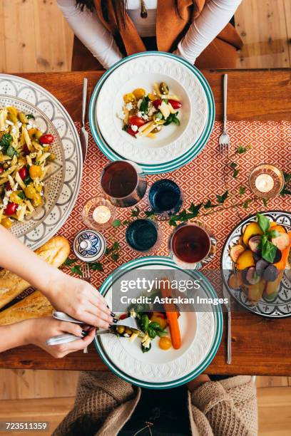 cropped image of womans hands serving food to friends at table - wine glass finger food stock-fotos und bilder