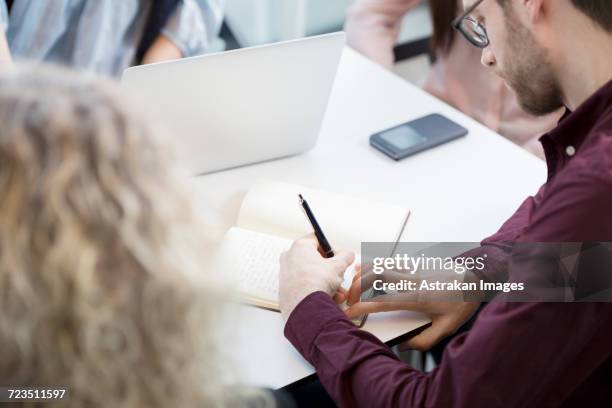 high angle view of businessman planning during meeting in office - arab businesswoman with books stock-fotos und bilder